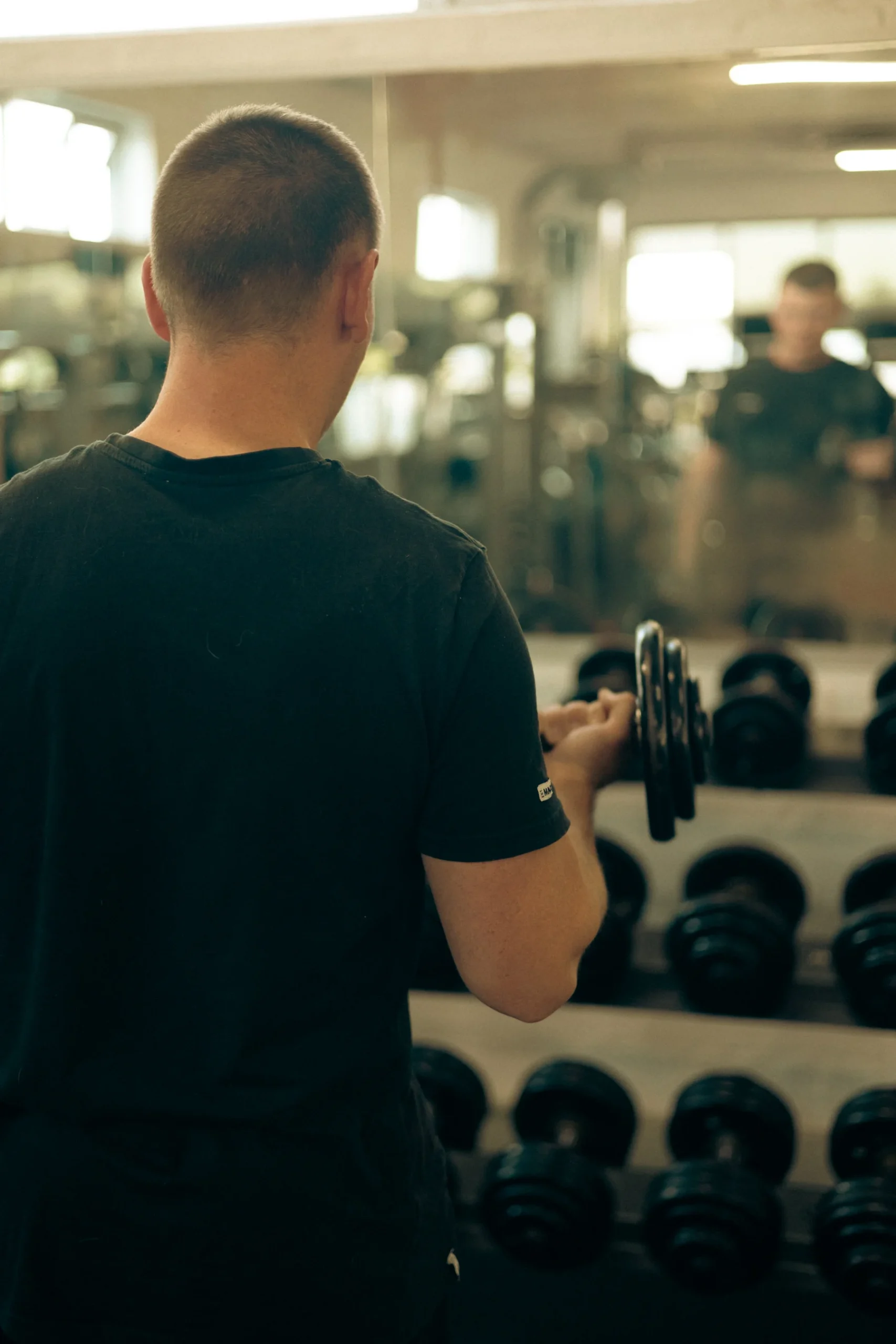 Member picking up dumbbells at Fit & Pure